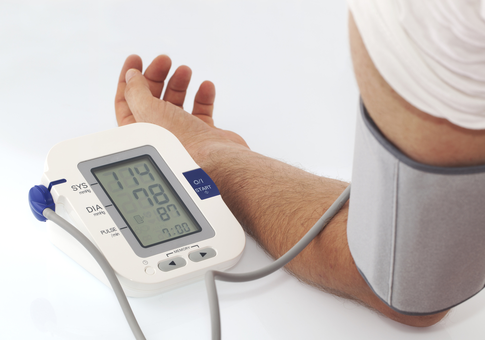 A person is taking a blood pressure reading while resting on a table