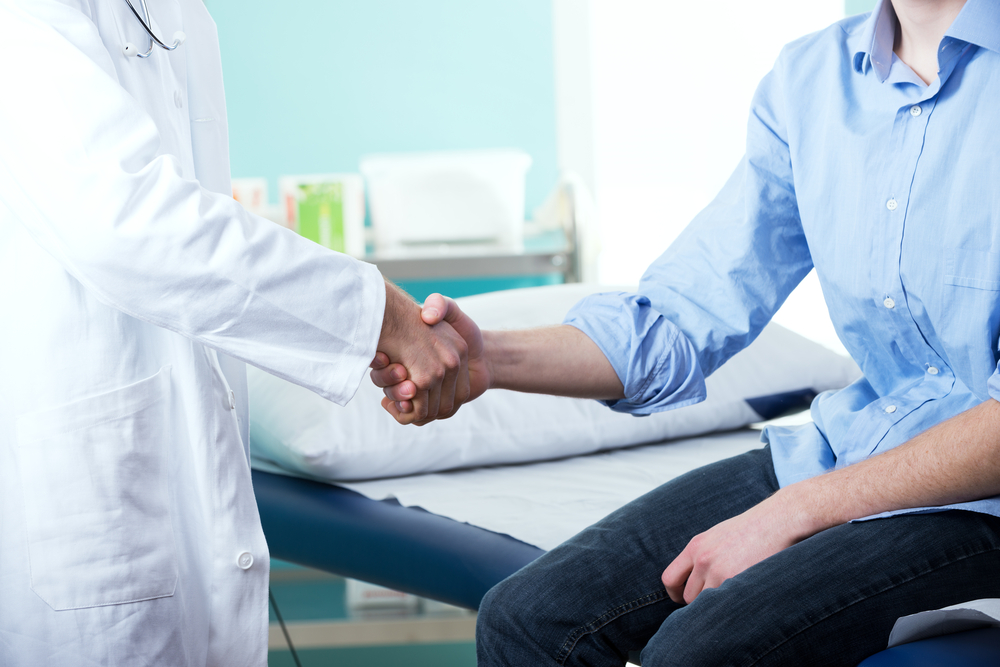 A doctor is shaking hands with a patient