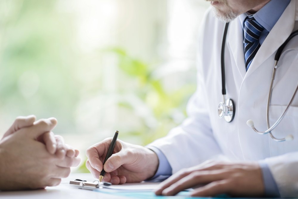 Primary care doctor reviewing pre-operative medical clearance paperwork with patient in Winter Haven Florida